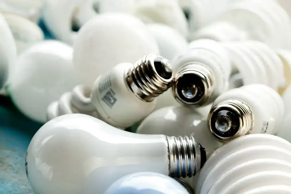 A heap of white compact fluorescent and incandescent bulbs