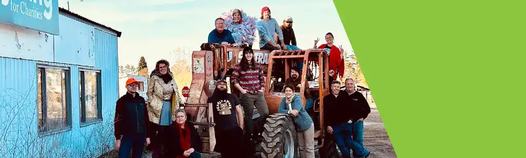 The BARC team gathered on and around a tractor in front of a blue building
