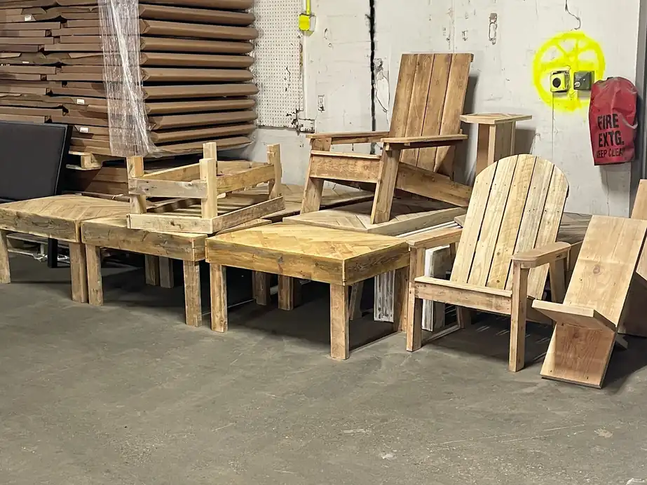 Adirondack chairs and tables built from reclaimed wood in a warehouse